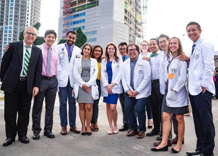 Dr. Panos Vasiloudes poses with medical students at the November topping off-ceremony for the new USF Health Morsani College of Medicine and Heart Institute.