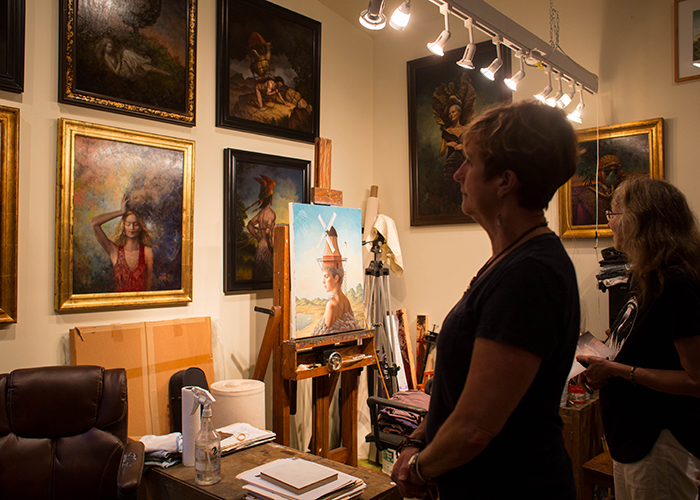 (L-R) Marty Bosy-Newlon and Kathy Barrera view oil paintings inside Steven Kenny's home studio.