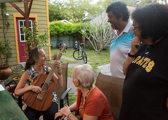 Diohn Brancaleoni plays tunes for AEHK members; Jan Richardson, Paul Barrera, and Annamarie Dotson, in her and her artist husband, Steven Kenny's backyard.