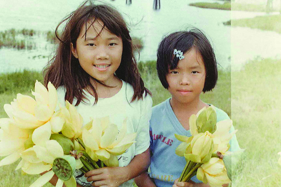 Water lilies found near a bridge delight Phuong, right, and her sister.