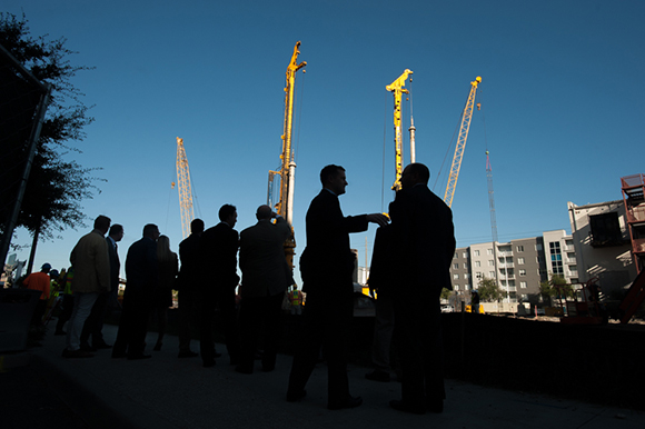 Officials gather near working cranes at the site of the upcoming Channel Club and Publix development in Channelside Friday morning. The group was there for a ceremonial groundbreaking for the media and other onlookers. Tampa Mayor Bob Buckhorn was on
