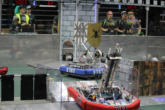 FIRST Robotics Competition robots negotiate defenses in the FIRST Stronghold game
