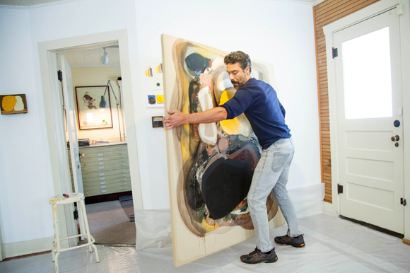 Artist Edgar Sanchez Cumbas packs up an installed painting for a client.