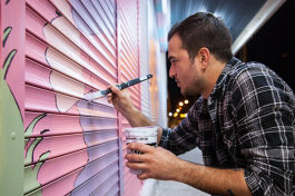 Charles Gallagher paints his first mural outside Cafe Hey and Oceanic Restaurant Equipment. 
