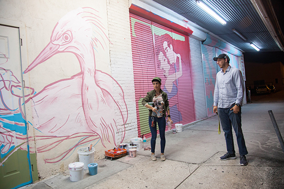 Michelle Sawyer preps to paint as Daniel Wind checks out the new evolving street art scape.