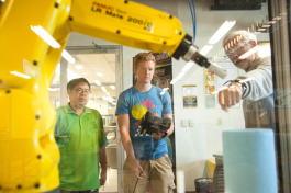 Ken Leung and Ben Faehn learn to program a robot from Professor Ron Smith at HCC.
