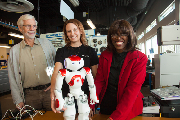 Ron Smith, Heather Canipe, and Shirley Dobbins with a humanoid used to teach students programming.