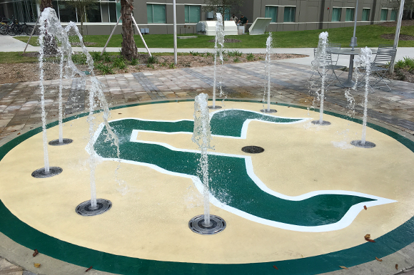 Outdoor gathering spaces at USF include a splash pad near some of the dorms.