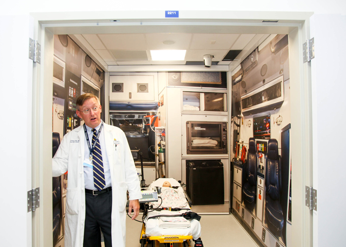 Dr., Paul Danielson, chief, div., of pediatric surgery, stands inside a simulated emergency ambulance for staff, students, and residence. 