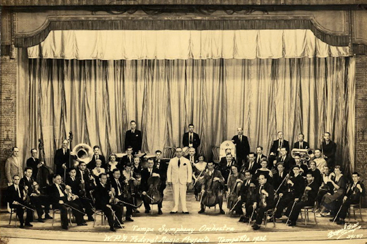 Tampa Symphony Orchestra at a building in Ybor with Wilfredo Rodríguez, a violinist in the front row.