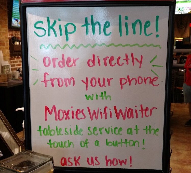 A sign at Moxies Cafe and Caterer introduces visitors to the Wifi Waiter.