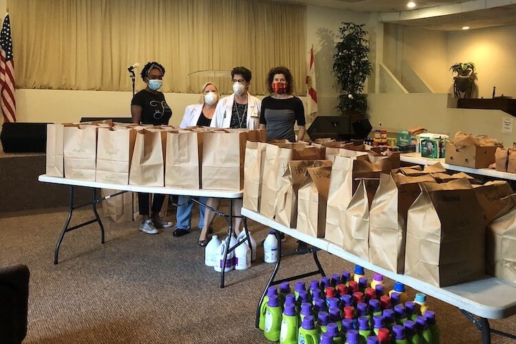 Tramaine Ware, Marcia Johansson, Denise Maguire, and Barbara with the food items and household supplies purchased by USF College of Nursing and the Tampa Police Department to assist Sulphur Springs families during the coronavirus pandemic.