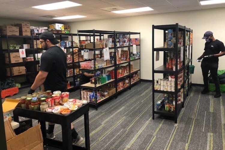Staff and volunteers restock shelves at USF food pantries with donated food and purchases made using cash donations.