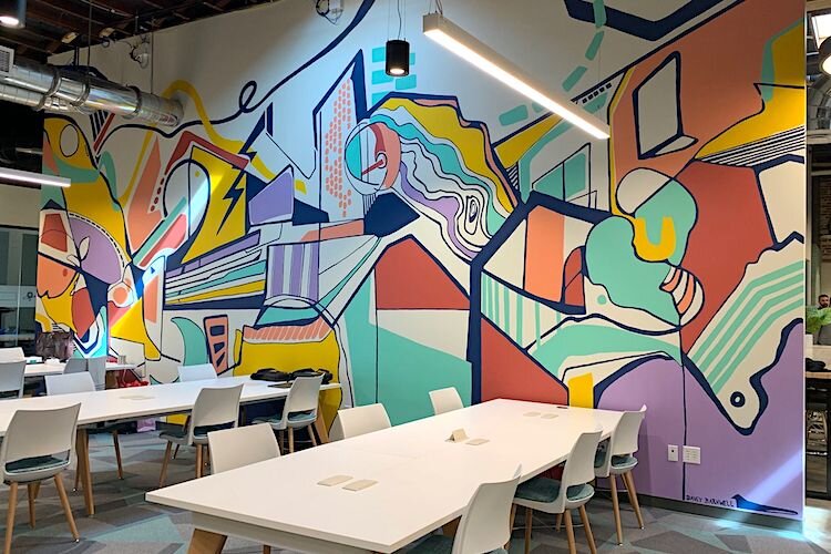An open collaboration area offers an abstract look at characteristics true to Tampa Bay including lightning bolts, the Riverwalk, and hockey sticks. Mural by Portland-based artist Davey Barnwell.