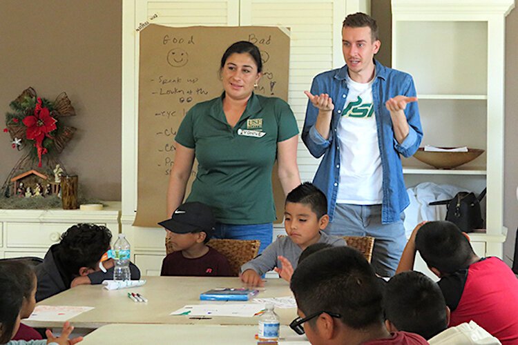 Logan Marx teaches a lesson on good communication skills at the Wholesome Winter Kids Camp alongside USF College of Nursing Assistant Professor Dr. Ivonne Hernandez.