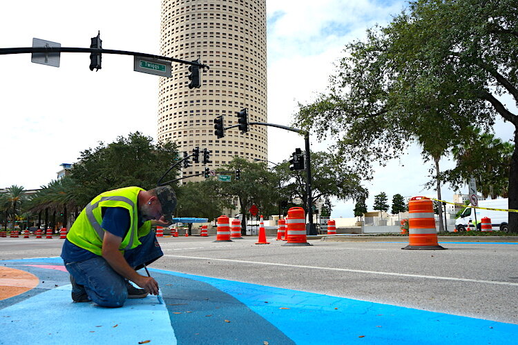 Artists and volunteers help paint portions of Tampa's downtown streets.