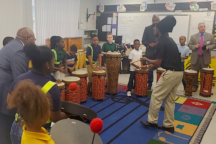Vistra CEO Brian Butler and THAP CEO Derrick Blue participate in drum circle as volunteers.