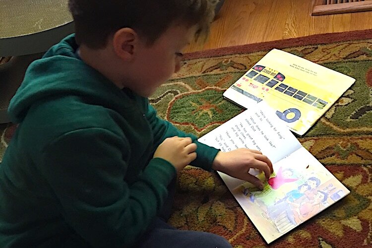 A child practices reading out loud to improve his reading skills.
