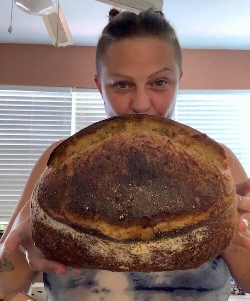 Jamie "Blue" Laukuf showing off a beautiful loaf of JB3 whole grain gluten-friendly naturally vegan country sourdough.