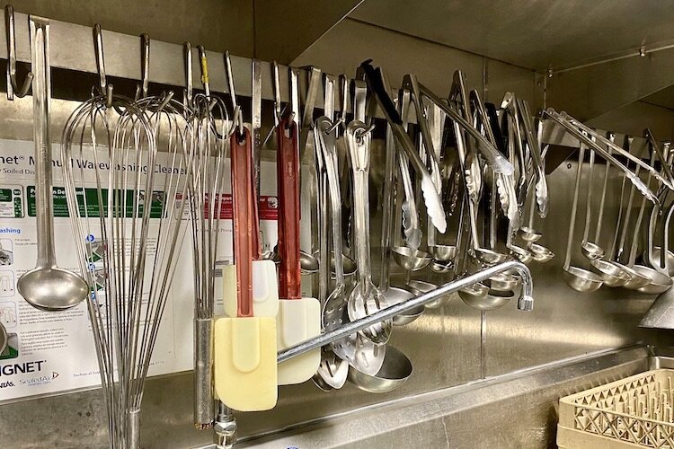 Utensils neatly lined up for use by kitchen staff at Meals on Wheels Tampa.