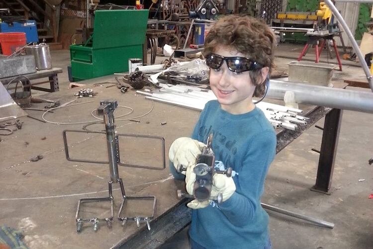 Students in the youth welding class are visibly excited about their metal creations.