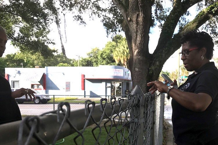 On a walk through the Jackson Heights neighborhood, Fran Tate tells her neighbor about a program funded by the East Tampa CRA that will help remove hazardous and unsightly tree limbs from her yard.