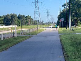 A walker heads down the newly opened Clearwater-PalmHarbor leg of the Pinellas Duke Energy Trail just after an August 5th ribbon-cutting ceremony.