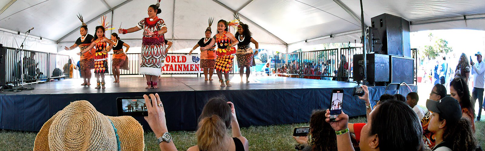  The crowd takes cell phone videos of a dance by the Tongans. The name of the culture rather than the name of the country, was used to identify the nations participating in this International Folk Fair.