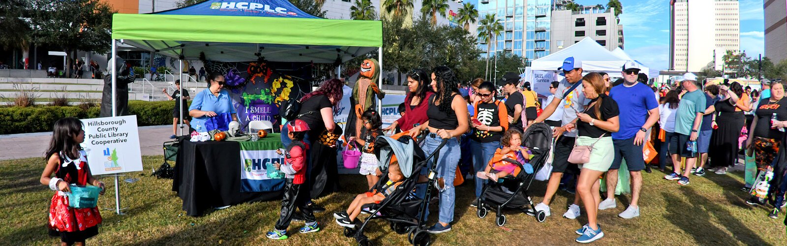 Long lines of families with children slowly inch along to get candy treats from the Hillsborough County Public Library Cooperative at the Curtis Hixon Waterfront Park in downtown Tampa.
