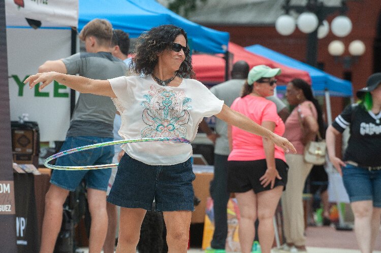 Gloria Mendieta dances with a hula hoop when not selling handcrafted jewelry at the “Celestial Hippie” tent at the Ybor City Saturday Market.
