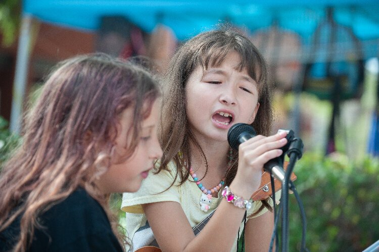 Tegan Kearney, 10, and Fafai Krofssik, 9, shared a microphone to sing for the crowd at the Ybor City Saturday Market.