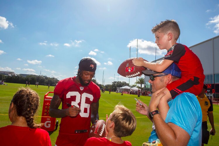 Bucs cornerback Don Gardner signs autographs and greets young fans during the team's annual training camp Community Impact Day event.