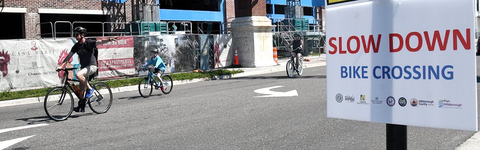  A large, conspicuous sign installed for World Car-Free Day at the corner of Seventh Avenue and Nuccio Parkway in Ybor City alerts motorists to pay attention to bicyclists crossing the intersection.