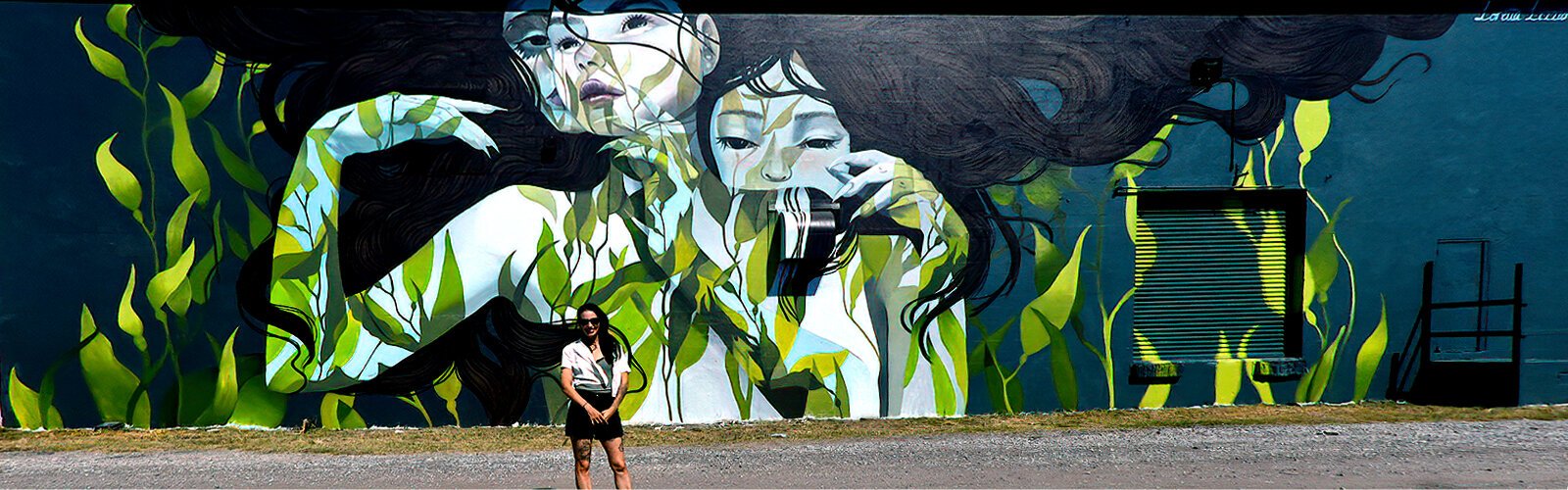 Australian artist and muralist Loretta Lizzio poses in front of her masterpiece created for the 9th edition of SHINE Mural Festival.