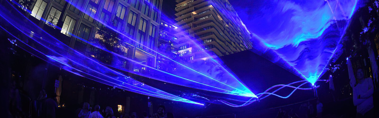 The wave-like layer of blue light moving above the crowd is meant to evoke thoughts about rising sea levels and the need to adapt to the changing environment.