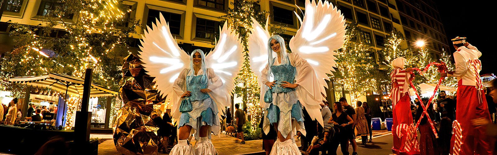 Ushering in the 2023 holiday season, two angels on stilts offer a festive backdrop for fun photo ops at the second annual Season Spectacular at Water Street Tampa.