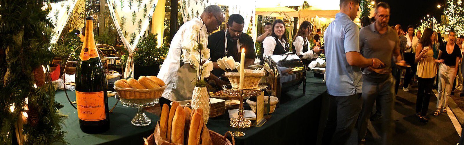 Visitors enjoy French festive food available for purchase at the Boulon Brasserie stand on Water Street during the Season Spectacular celebration.