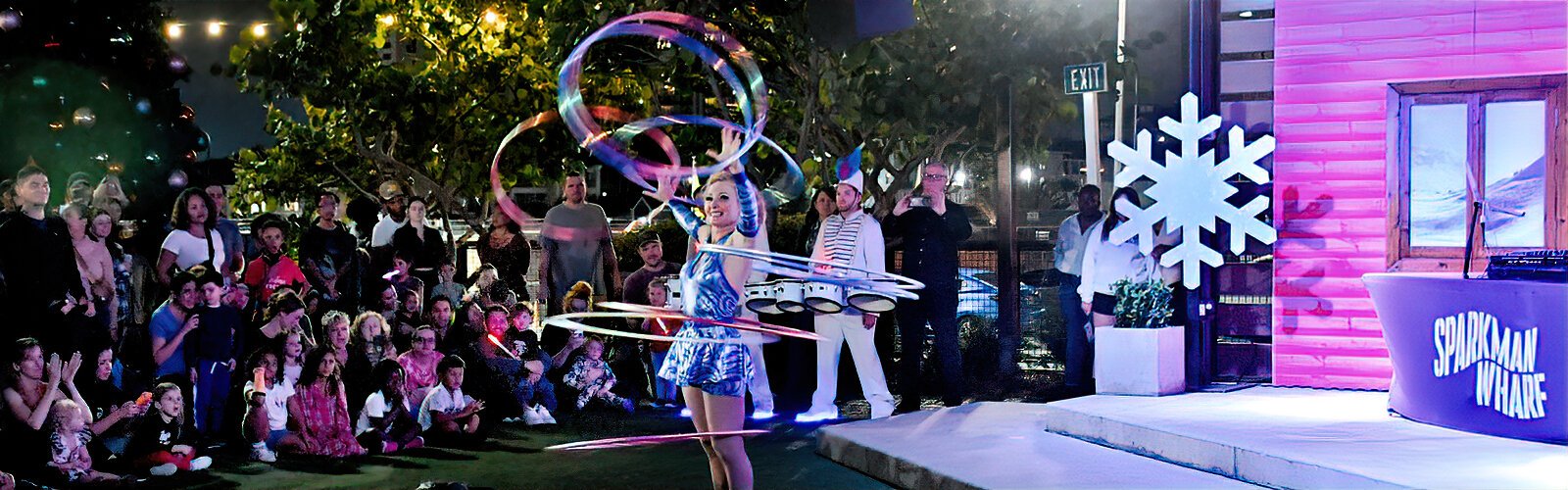 To celebrate the holiday season, a hoop dancer entertains a captive audience with her amazing skills at Sparkman Wharf 's Winter Wonder Wharf.