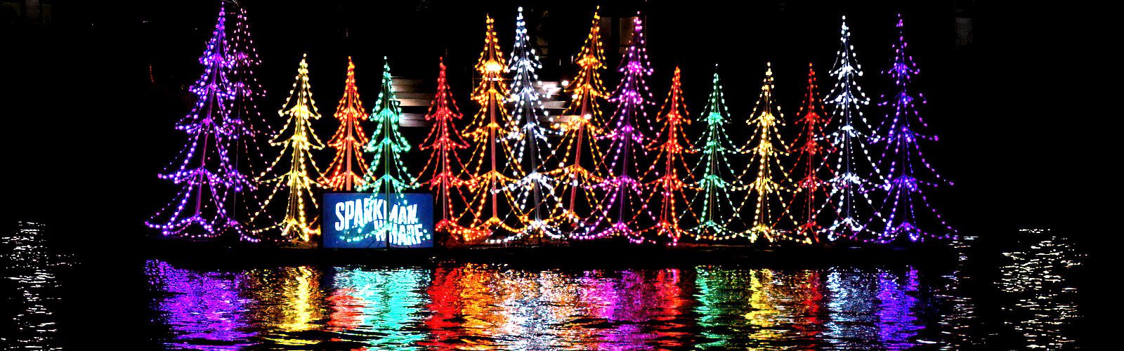 A colorful floating holiday display casts dazzling reflections into the Hillsborough River right across from the Winter Village at Curtis Hixon Waterfront Park in downtown Tampa.