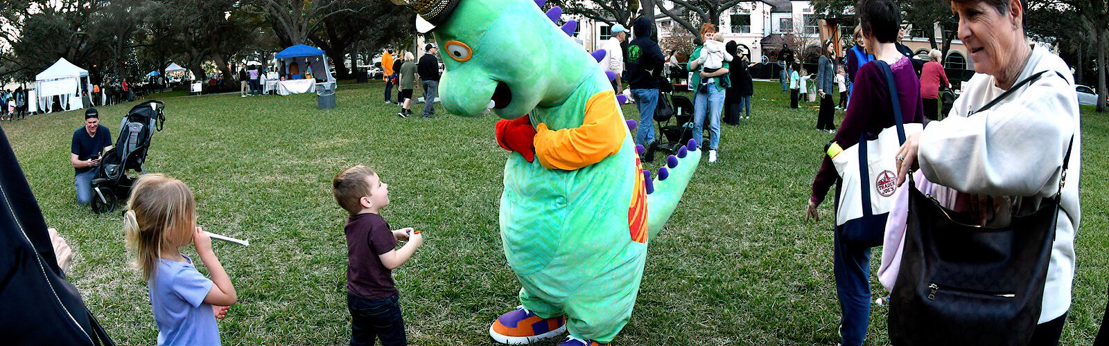 A little boy is not shy about meeting Morris the Explorasaurus from the Great Explorations Children’s Museum, who is roaming around North Straub Park looking for friends.