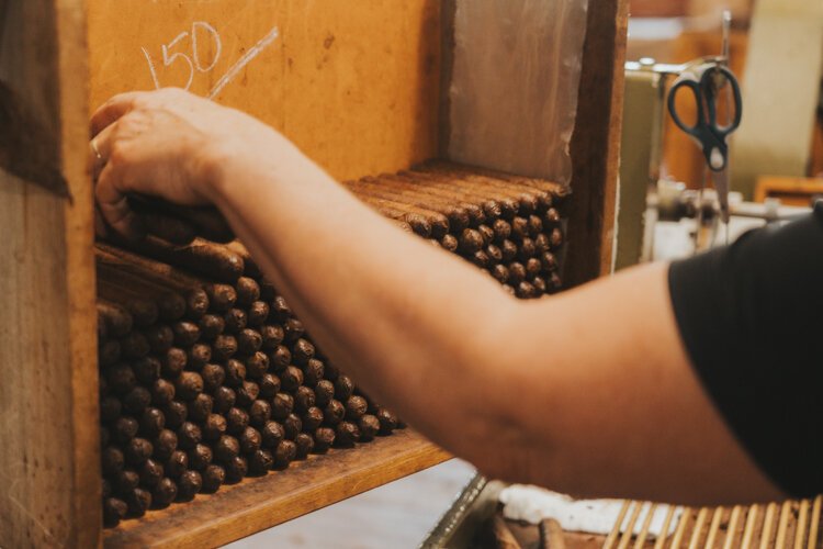 A worker stacks cigars at J.C. Newman's El Reloj factory. The boutique cigar factory produces 100,000 cigars a year.