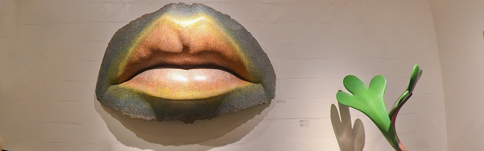 This striking lips sculpture “Chromorifice," by master sculptor Mark Aeling, is made with over 10,000 colored pencils cast with resin, fiberglass and aluminum to give a pixelated look.