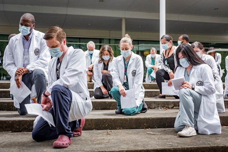 About 150 USF Health staff and faculty participate in #whitecoatsforblacklives protests held across the country. 