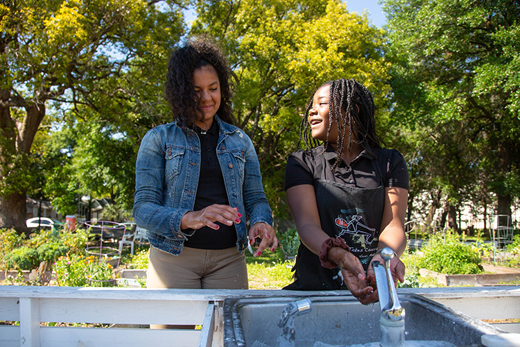 Anamarie Ramos, left, and Lifenia Nelson, wash up after painting a welcome mural.