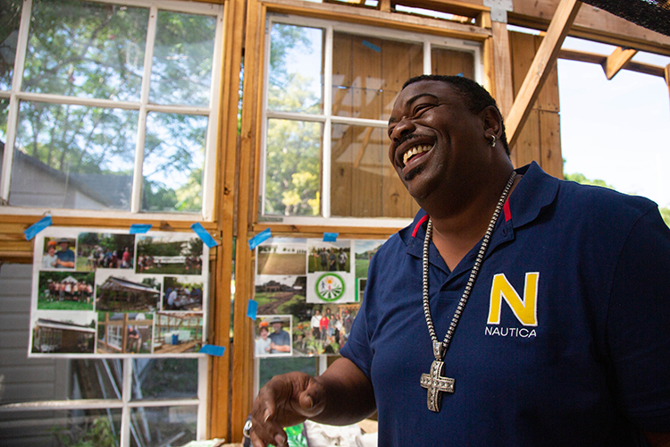 Andrew Joseph, a facilitator with the young adult group at THJCA, inside the aquaponic garden space for residents and THJCA students.