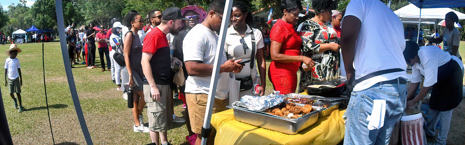 People stand in line for authentic Haitian cuisine sold by Haitian American vendors at the festival.