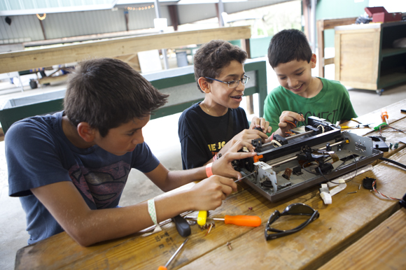 Friends (L-R) Tyler Visuvasam, Alejandro Acosta and Ian Pointer take apart a printer for fun. - Juli