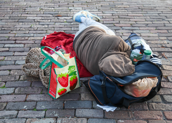 A meal is left for a man sleeping on the ground.