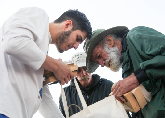 John Daniel DeBevoise, left, lets Tom Reid, a homeless man and his friend, select through books along the Riverwalk. 