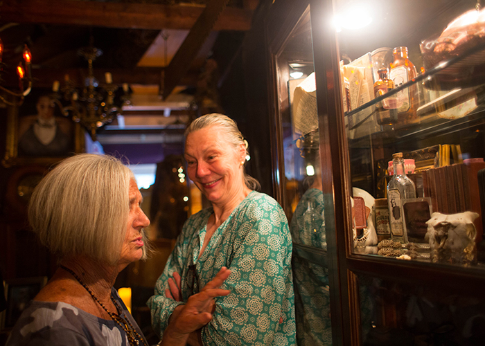 (L-R) Paola Nesmith, a jeweler, checks out Janna Kennedy-Hyten's costume art, and Halloween artifacts, inside her Historic Kenwood home.